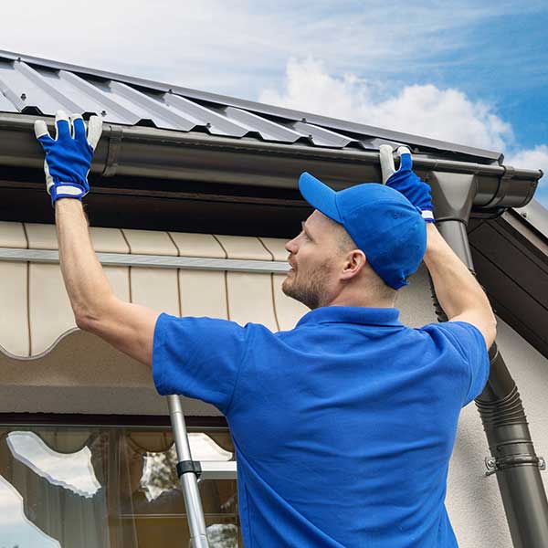 Man Installing House Roof Rain Gutter System in Logan, UT